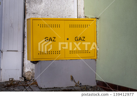 Bright yellow gas meter box marked GAZ, a crucial component of essential energy infrastructure for modern residential and commercial buildings 139412977