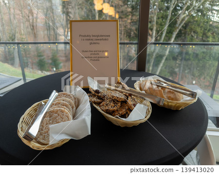 Buffet table with Gluten-free and low-gluten products sign, presenting healthy snack options and sliced bread for guests with specific dietary needs Buffet table with Gluten-free and low-gluten products sign, presenting healthy snack options and sliced bread for guests with specific dietary needs 139413020