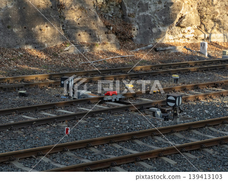 Railway track switch with signal indicators on a gravel bed, illustrating infrastructure and logistics for transportation safety, control, and precision engineering in a modern industrial rail network Railway track switch with signal indicators on a gravel bed, illustrating infrastructure and logistics for transportation safety, control, and precision engineering in a modern industrial rail network 139413103