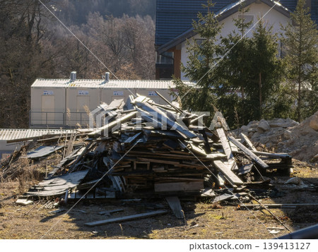 A large pile of abandoned construction waste and wooden planks sits on an outdoor site, representing environmental impact, industrial decay, and debris management challenges in modern urban areas 139413127