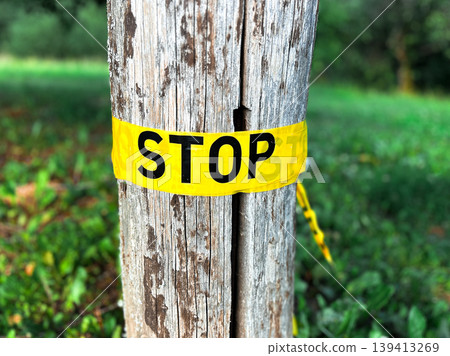 Yellow band with STOP sign on it. Emergency stop sign on tree trunk. Nature protection Yellow band with STOP sign on it. Emergency stop sign on tree trunk. Nature protection 139413269