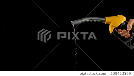 Gasoline drops dripping from fuel nozzle on dark background, minimal fuel flow. Concept of fuel depletion, shortage and energy crisis, macro detail, dramatic lighting. 139413599
