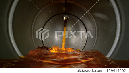 Gasoline jet pouring into metal fuel tank, inside view with dynamic splash and turbulence. Concept of refueling, fuel storage and energy supply, industrial environment. 139413602