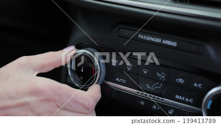 Close up senior woman adjusts the air conditioning system of a car. Temperature in the car. Close up senior woman adjusts the air conditioning system of a car. Temperature in the car. 139413789