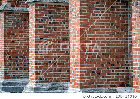 Bricks are stacked to create a series of columns on the exterior of an old building Bricks are stacked to create a series of columns on the exterior of an old building 139414080