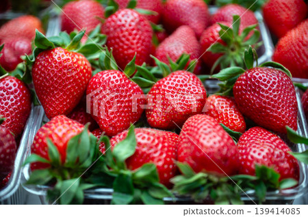 Strawberries fill clear containers at a market with bright colors and fresh appeal. Strawberries fill clear containers at a market with bright colors and fresh appeal. 139414085