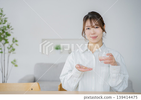 A woman drinking supplements 139414475