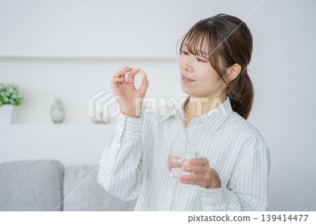 A woman drinking supplements 139414477