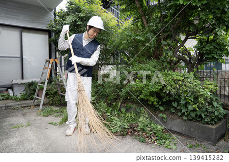 Workers cleaning up after cutting down garden trees Workers cleaning up after cutting down garden trees 139415282