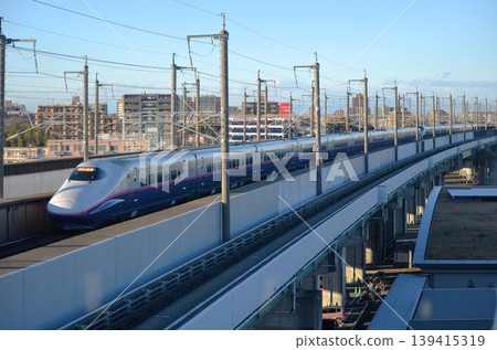 A Shinkansen E2 series train running through the winter twilight. A Shinkansen E2 series train running through the winter twilight. 139415319