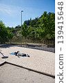 Woman Relaxing on Yoga Mat Outdoors in Sunny Park After Exercise 139415648
