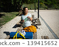 Woman Taking A Break With Water Bottle And Yoga Mat At Outdoor Park Picnic Table 139415652