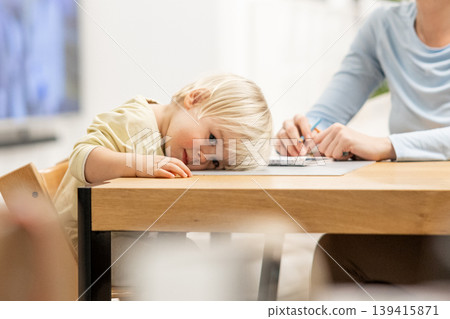 Exhausted toddler falling asleep during art lesson with mom Exhausted toddler falling asleep during art lesson with mom 139415871