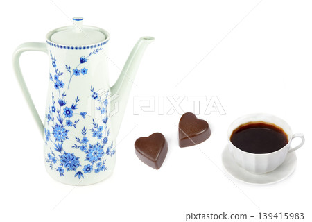 Vintage porcelain coffee pot with a cup of black coffee and heart-shaped chocolates isolated on white background. Vintage porcelain coffee pot with a cup of black coffee and heart-shaped chocolates isolated on white background. 139415983