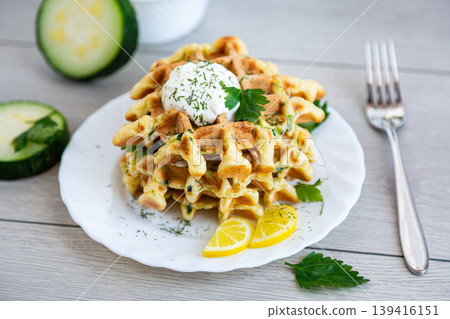 homemade zucchini waffles with creamy topping and lemon garnish homemade zucchini waffles with creamy topping and lemon garnish 139416151