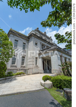 The exterior of the former Kagoshima Prefectural Government Building (Prefectural Government Memorial Hall), a registered tangible cultural property, captured in a vertical composition with fresh green leaves in the foreground (Kagoshima City). The exterior of the former Kagoshima Prefectural Government Building (Prefectural Government Memorial Hall), a registered tangible cultural property, captured in a vertical composition with fresh green leaves in the foreground (Kagoshima City). 139416478