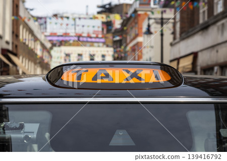Close up of a yellow taxi sign on a black cab in the city Close up of a yellow taxi sign on a black cab in the city 139416792