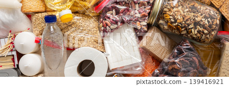 Essential home food stock for military operations and crises and for the period of quarantine and isolation, canned food, pasta, flour and nonperishable items,the concept of stay at home, banner Essential home food stock for military operations and crises and for the period of quarantine and isolation, canned food, pasta, flour and nonperishable items,the concept of stay at home, banner 139416921