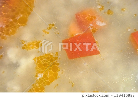 Close-Up of Vibrant Orange Bubbles and Red Object in Oily Mixture - Abstract Art Concept Close-Up of Vibrant Orange Bubbles and Red Object in Oily Mixture - Abstract Art Concept 139416982
