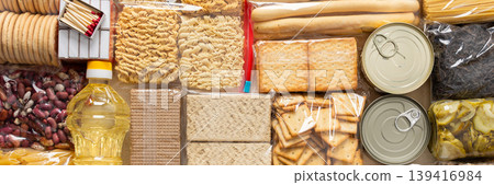 Home food supplies for quarantine and isolation, including canned food, cereals, pasta, and essential staples for survival, survival during military operations, the concept of stay at home, banner Home food supplies for quarantine and isolation, including canned food, cereals, pasta, and essential staples for survival, survival during military operations, the concept of stay at home, banner 139416984