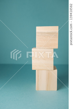 Stacked Wooden Blocks on a Blue Background Stacked Wooden Blocks on a Blue Background 139418582