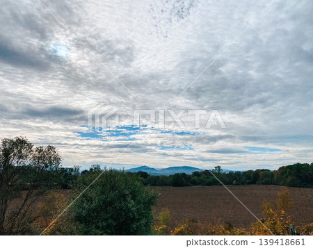 Expansive landscape with rolling hills under a dramatic cloudy sky showcasing natural beauty Expansive landscape with rolling hills under a dramatic cloudy sky showcasing natural beauty 139418661