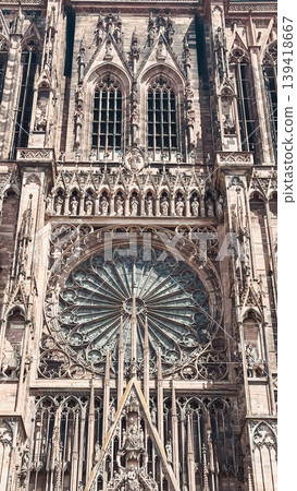 Intricate architectural details of a historic cathedral facade showcasing ornate stonework and a stunning rose window, reflecting artistic craftsmanship 139418667