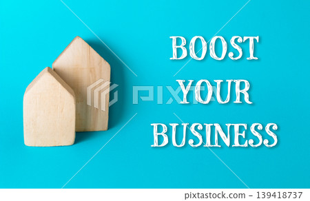 Two wooden houses are on a blue background with the words boost your business" Two wooden houses are on a blue background with the words boost your business" 139418737
