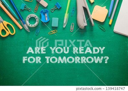 Colorful stationery supplies arranged on a green chalkboard background with motivational text Colorful stationery supplies arranged on a green chalkboard background with motivational text 139418747