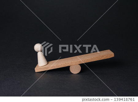Wooden seesaw with a small figure balancing on one end, symbolizing the concept of health and illness, showcasing the delicate balance of well-being and challenges Wooden seesaw with a small figure balancing on one end, symbolizing the concept of health and illness, showcasing the delicate balance of well-being and challenges 139418761