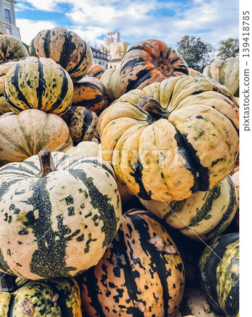 Colorful assortment of striped pumpkins stacked together in a vibrant display, showcasing the beauty of autumn harvest and seasonal produce Colorful assortment of striped pumpkins stacked together in a vibrant display, showcasing the beauty of autumn harvest and seasonal produce 139418785