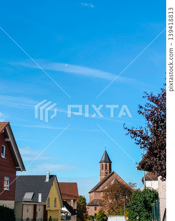 Charming residential street with colorful houses and a historic church under a clear blue sky Charming residential street with colorful houses and a historic church under a clear blue sky 139418813