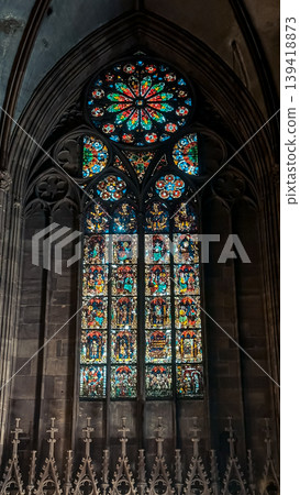 Stained glass window featuring intricate designs and vibrant colors, illuminating the interior of a historic cathedral with gothic architecture and spiritual ambiance Stained glass window featuring intricate designs and vibrant colors, illuminating the interior of a historic cathedral with gothic architecture and spiritual ambiance 139418873