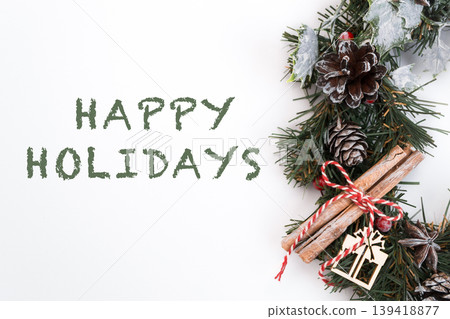 Festive holiday wreath with pinecones, cinnamon sticks, and cheerful message for seasonal celebration Festive holiday wreath with pinecones, cinnamon sticks, and cheerful message for seasonal celebration 139418877