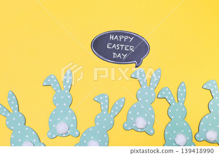 Group of Easter rabbits are standing in a row on a yellow background Group of Easter rabbits are standing in a row on a yellow background 139418990
