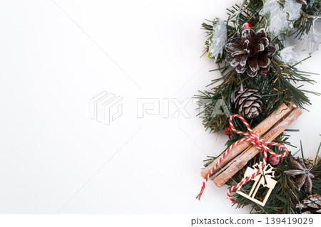 Festive Christmas wreath with pinecones, cinnamon sticks, and decorative elements on white background Festive Christmas wreath with pinecones, cinnamon sticks, and decorative elements on white background 139419029