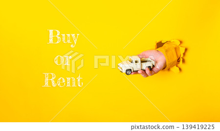 Hand holding a toy truck emerging from a yellow background with text suggesting buy or rent options Hand holding a toy truck emerging from a yellow background with text suggesting buy or rent options 139419225