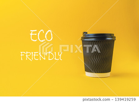Black coffee cup with a white lid sits on a yellow background Black coffee cup with a white lid sits on a yellow background 139419259