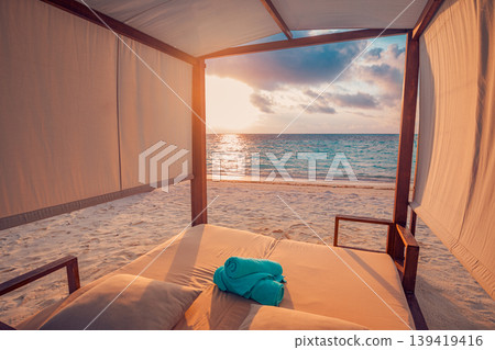 Luxury vacation beach canopy at sunset overlooking the ocean view with vibrant relaxation vibes and a beautiful tropical travel background scenery Luxury vacation beach canopy at sunset overlooking the ocean view with vibrant relaxation vibes and a beautiful tropical travel background scenery 139419416
