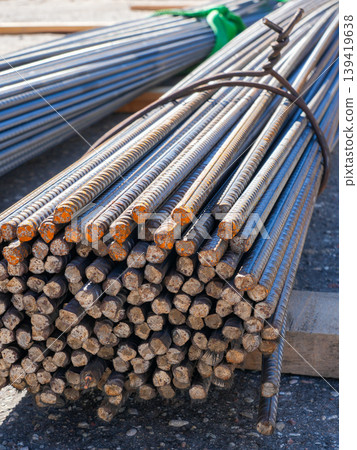 Bundled steel rebar rods with rusted ends tied for transport on construction site close-up detail 139419638
