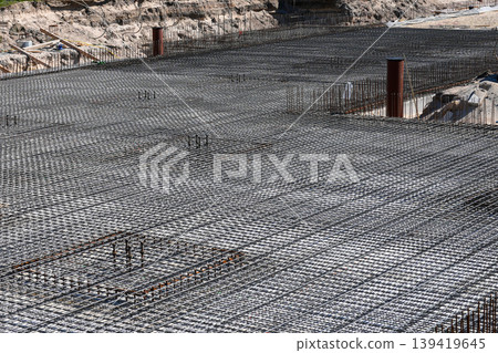 Steel reinforcement mesh grid prepared for concrete foundation at large construction site 139419645
