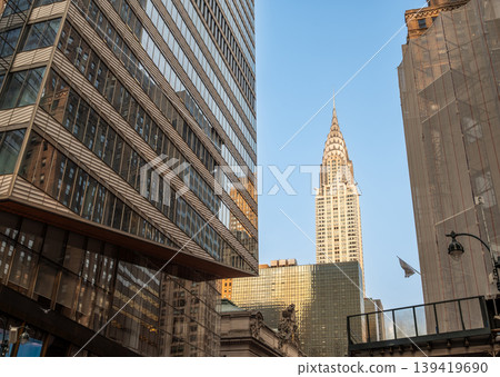 New york, usa august 17,2024. Chrysler building art deco skyscraper architecture dominates the urban commercial skyline between modern office buildings in manhattan New york, usa august 17,2024. Chrysler building art deco skyscraper architecture dominates the urban commercial skyline between modern office buildings in manhattan 139419690