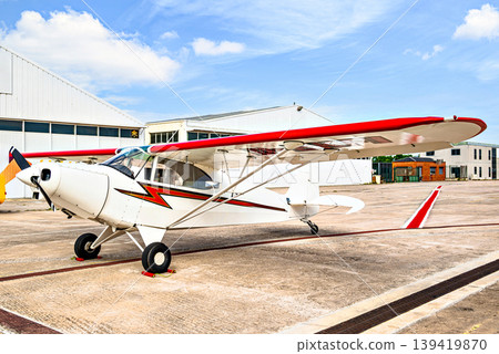 A single-engine ultralight aircraft waiting to take off at the airfield. 139419870