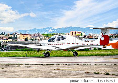 A single-engine ultralight aircraft waiting to take off at the airfield. 139419891