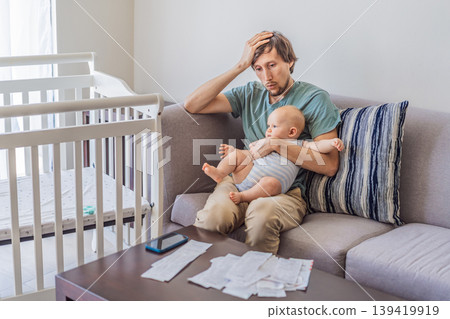 Father sitting on sofa holding baby while calculating monthly expenses with receipts at home. Stressed dad managing budget and childcare. Financial stress, parenthood and real life concept Father sitting on sofa holding baby while calculating monthly expenses with receipts at home. Stressed dad managing budget and childcare. Financial stress, parenthood and real life concept 139419919