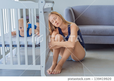 Very tired mother sitting by baby crib at home feeling exhausted. Sleep deprived mom caring for newborn at night. Parenting fatigue, motherhood stress, childcare and real family life concept Very tired mother sitting by baby crib at home feeling exhausted. Sleep deprived mom caring for newborn at night. Parenting fatigue, motherhood stress, childcare and real family life concept 139419920