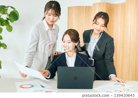 Three Japanese female business professionals are having a meeting in their office, looking at their laptops and documents. Three Japanese female business professionals are having a meeting in their office, looking at their laptops and documents. 139420643