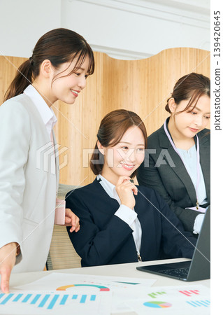 三位年輕的女性商務人士正在開會,同時看著白板上的圖表;這是辦公室裡的一次示範。 三位年輕的女性商務人士正在開會,同時看著白板上的圖表;這是辦公室裡的一次示範。 139420645