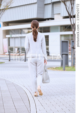 一位身穿白色套裝的女子從背後走過街道——春日商業景象——通勤畫面 一位身穿白色套裝的女子從背後走過街道——春日商業景象——通勤畫面 139420772