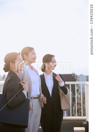 三位職業婦女在晨光中凝視前方;一群身著西裝的上班族前往上班的商業畫面。 三位職業婦女在晨光中凝視前方;一群身著西裝的上班族前往上班的商業畫面。 139420816